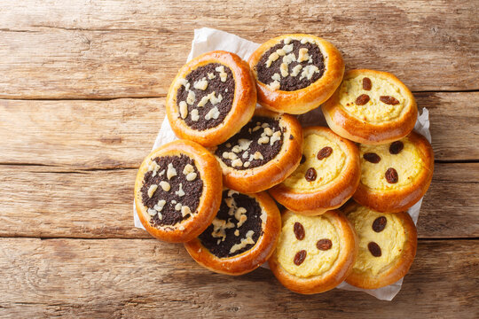 Traditional sweet yeast dough kolache kolace with delicious poppy seeds filling and streusel topping and cream cheese filling closeup on the wooden table. Horizontal top view from above