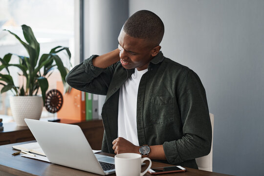 Man, office and neck pain with laptop at desk with injury or health problem with stress or anxiety. Overworked, muscle and copywriter fatigued in company with tired, social media and burnout in work.
