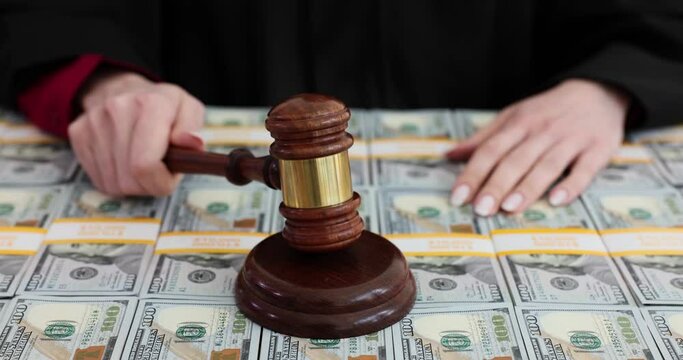 Judge gavel hits stack of 100 bills