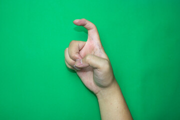 hand showing sign, sign language of alphabet of X, on green background