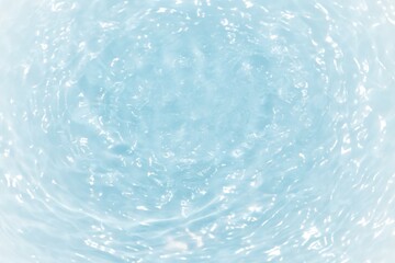 Blue water with ripples on the surface. Defocus blurred transparent blue colored clear calm water surface texture with splashes and bubbles. Water waves with shining pattern texture background.	