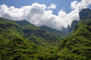 Mountainous landscape with mountain slopes on a cloudy summer day, on a train vacation travel