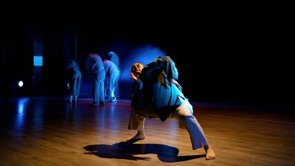 Beautiful movements of a dancer. Performance, girls lying on stage, stage light. In a club, girls lying on the stage dance under the concert lights. The girl lies on the stage. Ballerina performs.