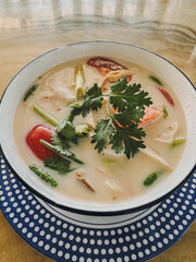 Vertical photo, Thai spicy coconut soup with chicken, traditional street food in Thailand.