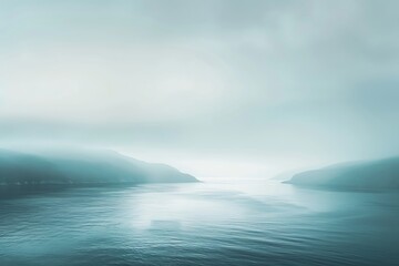 Naklejka premium Serene seascape with misty mountains in the distance, creating a peaceful and tranquil atmosphere, perfect for relaxation and meditation.