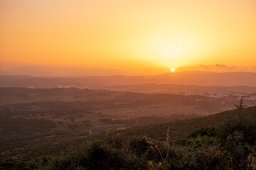 the sun sets over the mountains of cadiz