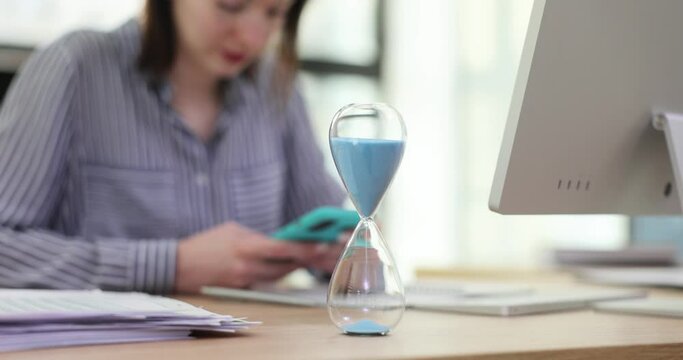 Woman manager is distracted from work and uses smartphone and social networks