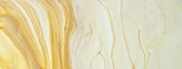 Abstract fluid art background yellow and golden colors. Liquid marble. Acrylic painting with beige gradient and splash.