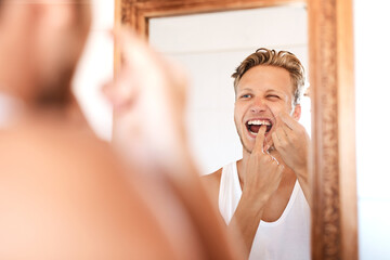 Health, teeth and man with floss by mirror in home for self care, wellness and morning routine....
