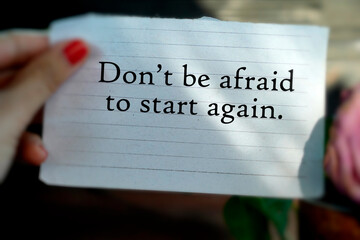 Text message on the thorn paper in hand - Don't be afraid to start again. Life motivational concept...
