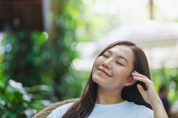 Portrait image of a young woman with closed eyes enjoying and relaxing in the outdoors