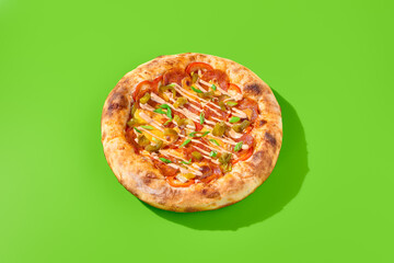 American pizza with thick crust, salami sausage, pepperoni, and spicy jalapeno peppers on a vibrant green background with hard shadows in a minimalist style. Pizza. Takeaway, minimalism, horizontal