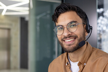 Smiling customer service representative wearing a headset in a modern office environment