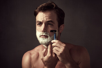 Man, blade and foam for shaving in studio, cleaning and skincare for grooming on black background....