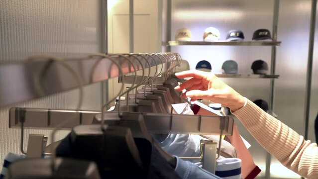 Pampered consumer looks at sportswear with a cap in background. The market offers a diverse range of sportswear, which creates an oversupply of purchases. concept of overconsumption