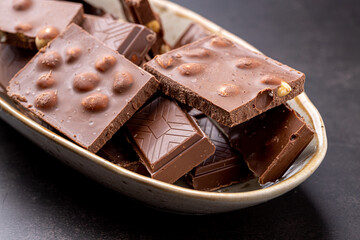 Chocolate cupcake with icing and chocolate bar in Dark lighting,Homemade delicious chocolate muffin on wooden background close-up