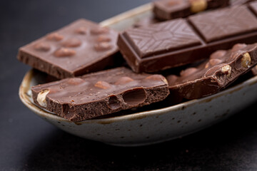 Chocolate cupcake with icing and chocolate bar in Dark lighting,Homemade delicious chocolate muffin on wooden background close-up