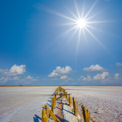 dry saline land with old wooden construction ruin under a sparkle sun