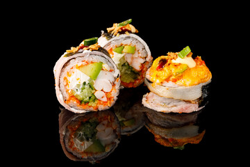 Sushi Hot Roll, Sushi menu. Japanese food.Set with fried and baked rolls, sushi on a black board on a light table.