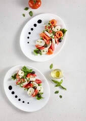 Caprese salad duo with classic and salmon variations, top view on white plates. Ideal for gourmet food marketing and recipe content