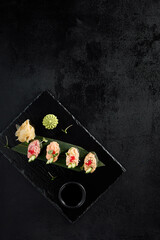Elegant spicy sushi assortment with salmon, shrimp, tuna, and eel, top view on dark slate