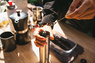 Close up The barista is preparing a fresh brew by pouring roasted Arabica beans into a manual...