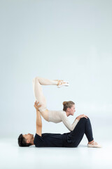 Classical Ballet Ideas. Flexible International Sportive Couple of Asian Man and Caucasian Woman Performing As Ballet Dancers On Grey in Studio During Suppots As Classical Dance And Choreography. © danmorgan12