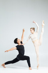 Dancing Concepts. Sensual Passionate Professional International Sportive Couple of Asian Man and Caucasian Woman Performing As Ballet Dancers On Grey in Studio During Suppots As Classical Dance © danmorgan12