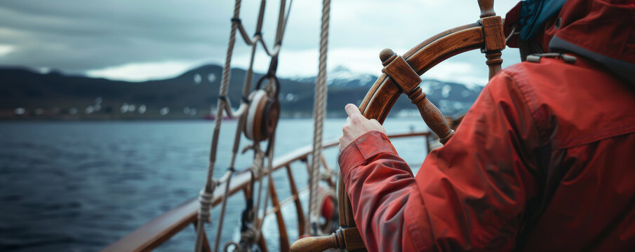 Captain with hands on the ship rudder steering the boat. With copy space and sea background.