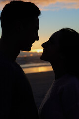 Sunset sky, silhouette and couple on beach with touch for romance, bonding and tropical holiday....