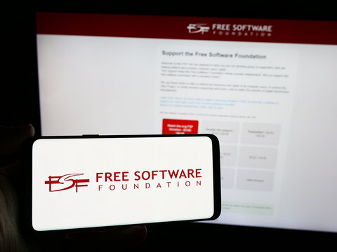 Stuttgart, Germany - 05-22-2024: Person holding smartphone with logo of US organisation Free Software Foundation (FSF) in front of website. Focus on phone display.