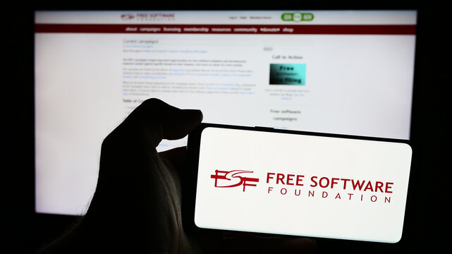 Stuttgart, Germany - 05-22-2024: Person holding mobile phone with logo of US organisation Free Software Foundation (FSF) in front of web page. Focus on phone display.