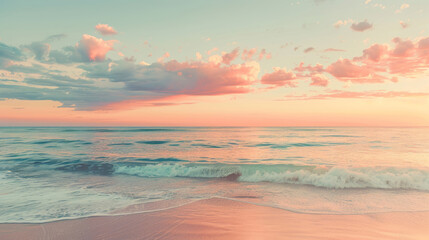 Fototapeta premium A beautiful beach under a pink and orange sunset sky features a calm sea and a sandy shore.