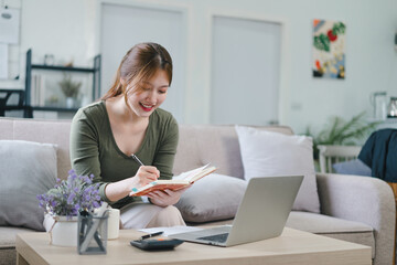 Online education, e-learning. Happy asian young woman studying remotely, using a laptop, listening...