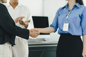 Business meeting between colleagues shaking hands in modern office.