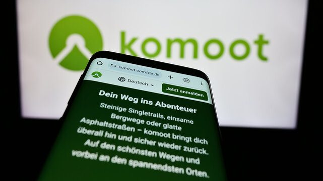 Stuttgart, Germany - 05-23-2024: Cellphone with web page of German route planning app company komoot GmbH in front of business logo. Focus on top-left of phone display.