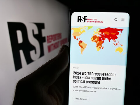 Stuttgart, Germany - 05-23-2024: Person holding cellphone with webpage of international organisation Reporters Without Borders in front of logo. Focus on center of phone display.