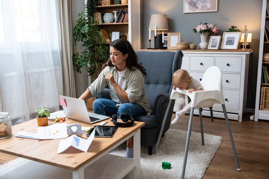 Young single divorced mother with baby using laptop computer for video call with her lawyer, talking about ex husband who not paying alimony and expenses and cost of living with small child.