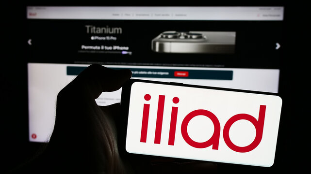Stuttgart, Germany - 05-23-2024: Person holding mobile phone with logo of telecommunications company Iliad Italia SpA in front of business web page. Focus on phone display.