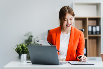 young Asian businesswoman, dressed in a formal suit, navigates complexities of the stock market as...