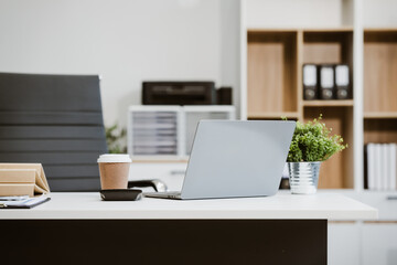 An empty, modern office space with a clean desk and sleek furniture offers a bright, comfortable workspace for business, featuring contemporary design elements and ample natural light.