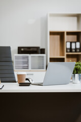 An empty, modern office space with a clean desk and sleek furniture offers a bright, comfortable...