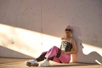 Attractive young gay man, heavily makeup, with pink hair, sunglasses, leather top and pants,...