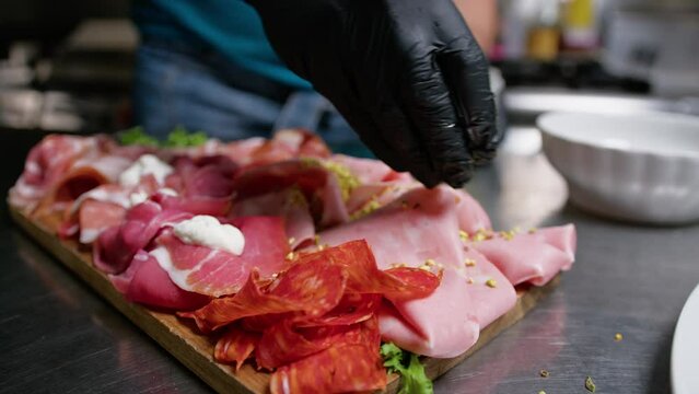 Chef Making Italian Cold Appetizer Food With Salami And Prosciutto In Restaurant