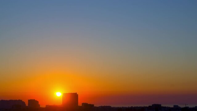 Cloudless Sunrise over a Seaside Town. Time Lapse