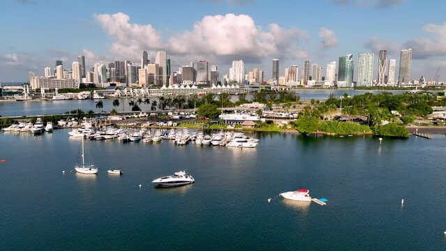 aerial push over boat in bay leading into the miami florida skyline
