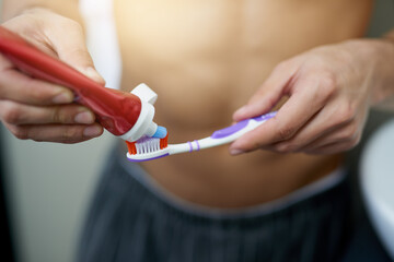 Bathroom, hands and man with toothbrush in home for dental care, getting ready and grooming. Cleaning, health and person with toothpaste, wellness and morning routine for hygiene, teeth and brushing.