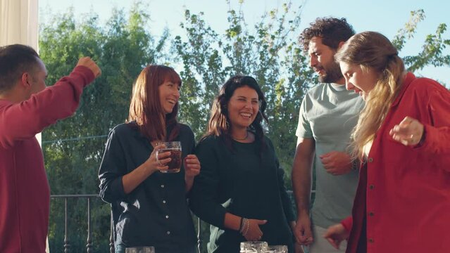Friends Celebrating Outdoors with Drinks standing on a balcony, enjoying a lively and joyful time together holding mugs of beer