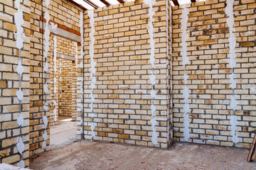 The image captures the interior of a building in progress, with a brick wall unfinished, showcasing the construction sites ongoing development and structure taking shape