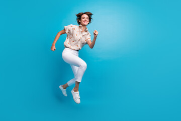 Full length photo of glad positive funny girl running fast empty space empty space isolated on blue...